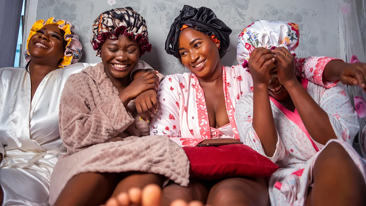 Women on a girls night wearing silk bonnets to protect their hair
